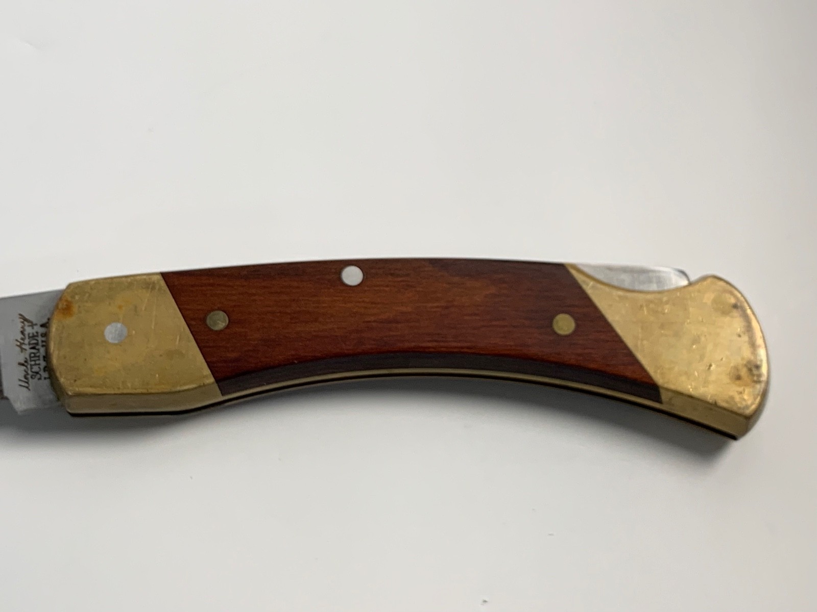 Vintage Schrade Uncle Henry LB 7 lockback with brass handle, wooden grip, and “Made in U.S.A.” engraving on side.