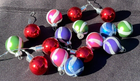 Lot of 16 round Christmas balls with multicolor horizontal stripes in red, green, silver, and pink, tied with black wire.