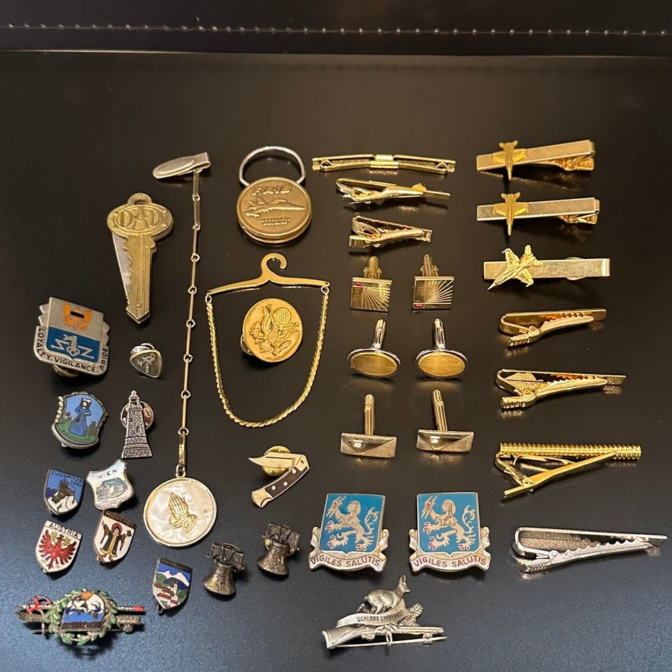 A curated estate lot of tie clips, cufflinks, and military/aviation pins — essentially a wearable history museum in a single box.
