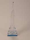 Clear vintage Lucite Empire State Building miniature with blue base, gold spire, and detailed footstep design.
