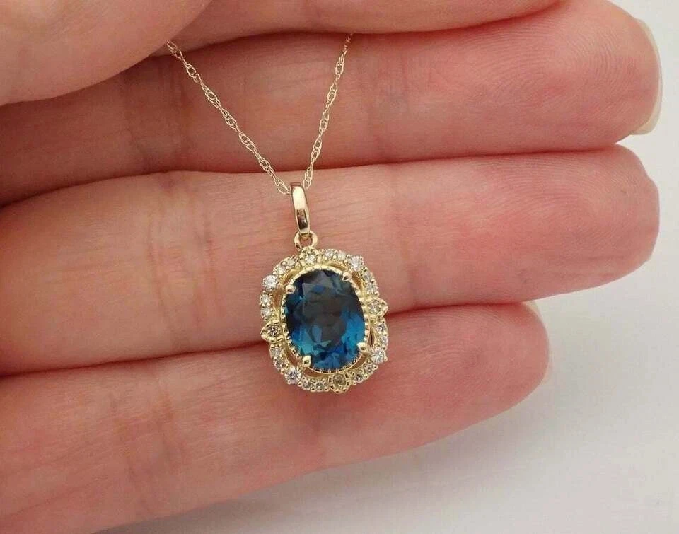 Colgante con halo de topacio azul Londres corte ovalado de 2,26 quilates cadena gratuita de oro amarillo de 14 quilates Foto 2 de 4