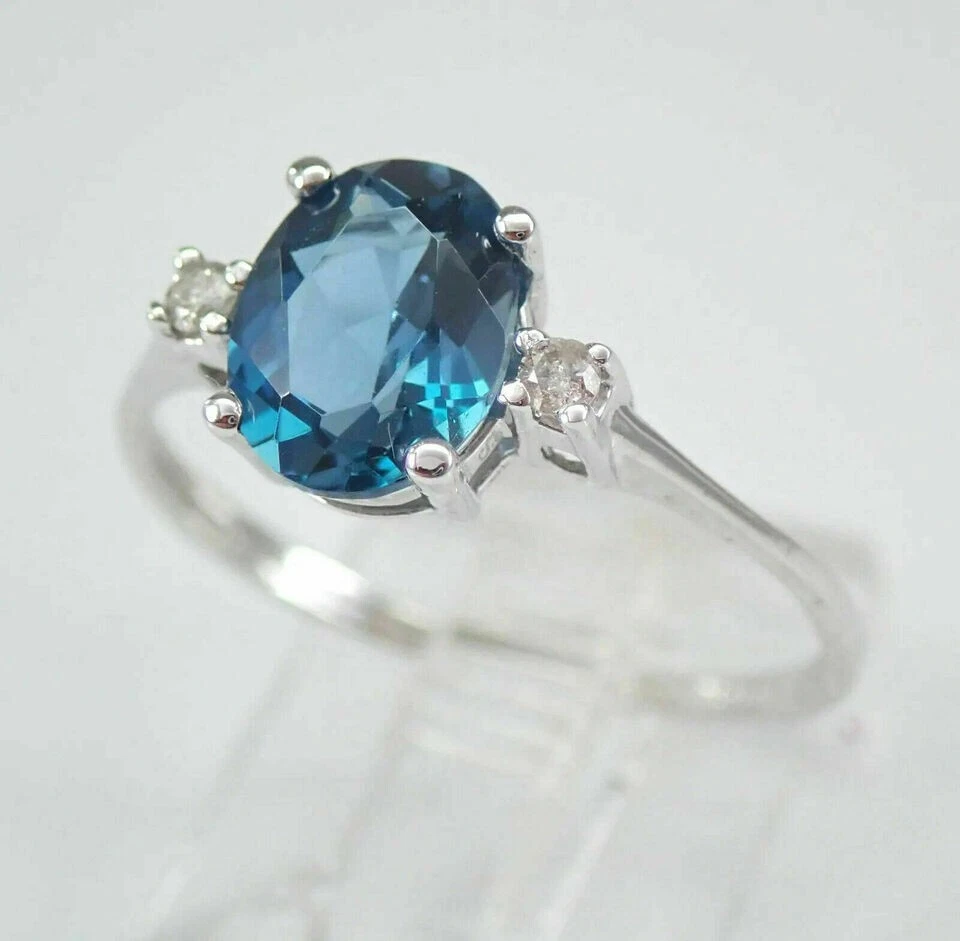 Anillo de compromiso de tres piedras con topacio azul corte ovalado de 2 quilates acabado en oro blanco de 14 quilates Foto 3 de 4