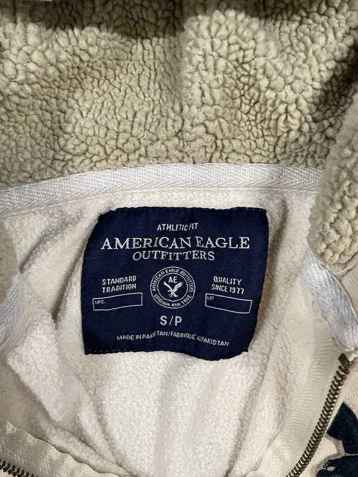 Sudadera con Capucha American Eagle Marfil Para Mujer Pequeña Cremallera Sherpa Forrada Clásica Grande Logo Foto 2 de 4