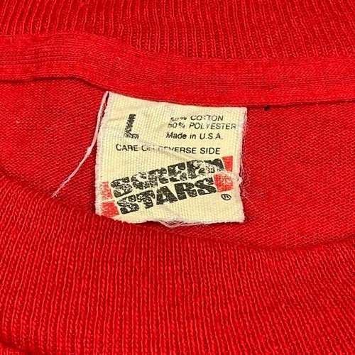 Red vintage 80s tech shirt with white printed text “80s True Stars,” size L, single stitch across the chest.