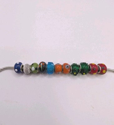 11 Unmarked Glass Bead Charms In A Variety Of Colours And Designs