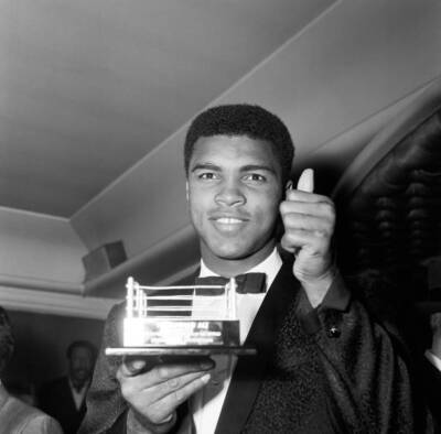 Boxer Muhammad Ali holding up a miniature boxing ring which was pr- Old Photo