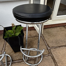 A Black Faux Leather Upholstered Bar Stool, Chrome Metal Frame, Black.