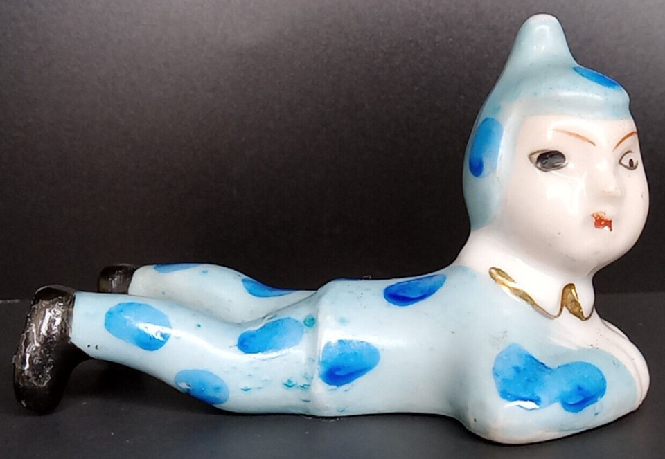A lying-down polka-dot clown/elf/pixie figure marked 'Japan' — the purest form of mid-century ceramic weirdness that belongs on every interesting person's shelf.