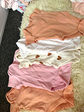 Bundle of first size baby vests and sleepsuits