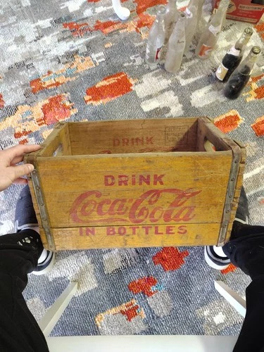 vintage wooden Coca-Cola crate designed to carry bottles.