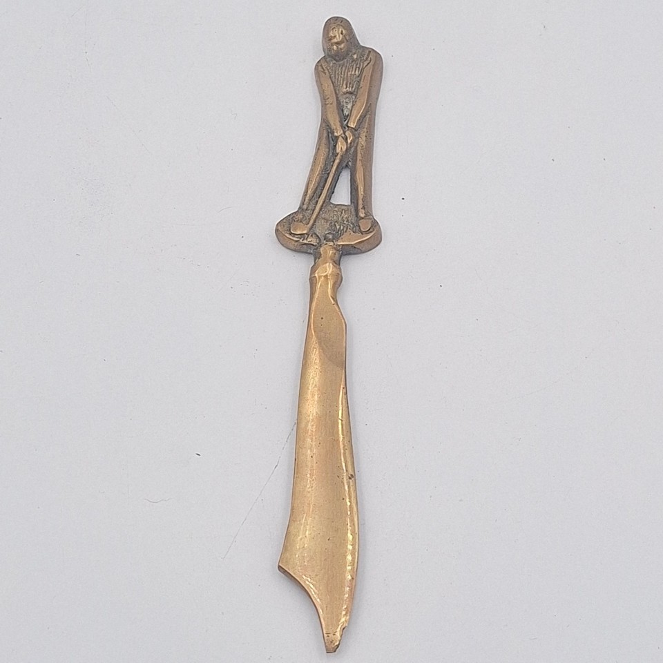 A 1930s brass golfer figurine letter opener — a tiny sculptural piece of sporting history that doubles as a working desk tool.