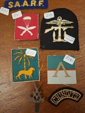 A collection of military badges and cloth insignia ww2 NOT sold as originals