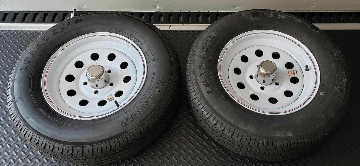 A pair of trailer_tires mounted on white steel wheels