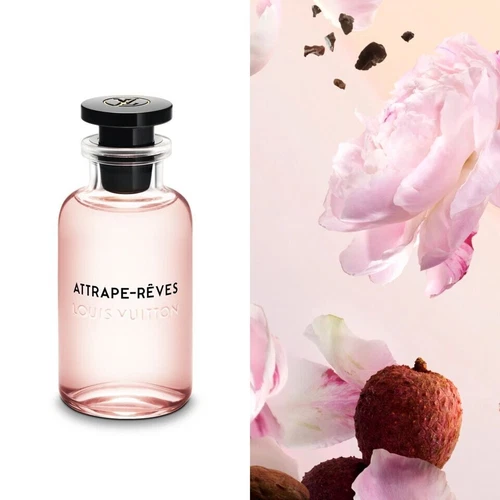 Clear glass bottle of Louis Vuitton Attrape-Rêves Eau de Parfum with black cap, labeled in black text, beside pink flowers.