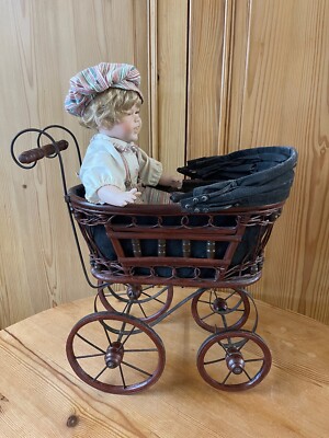 Antiker kleiner Puppenwagen mit Faltdach aus Holz und Metall bespielt
