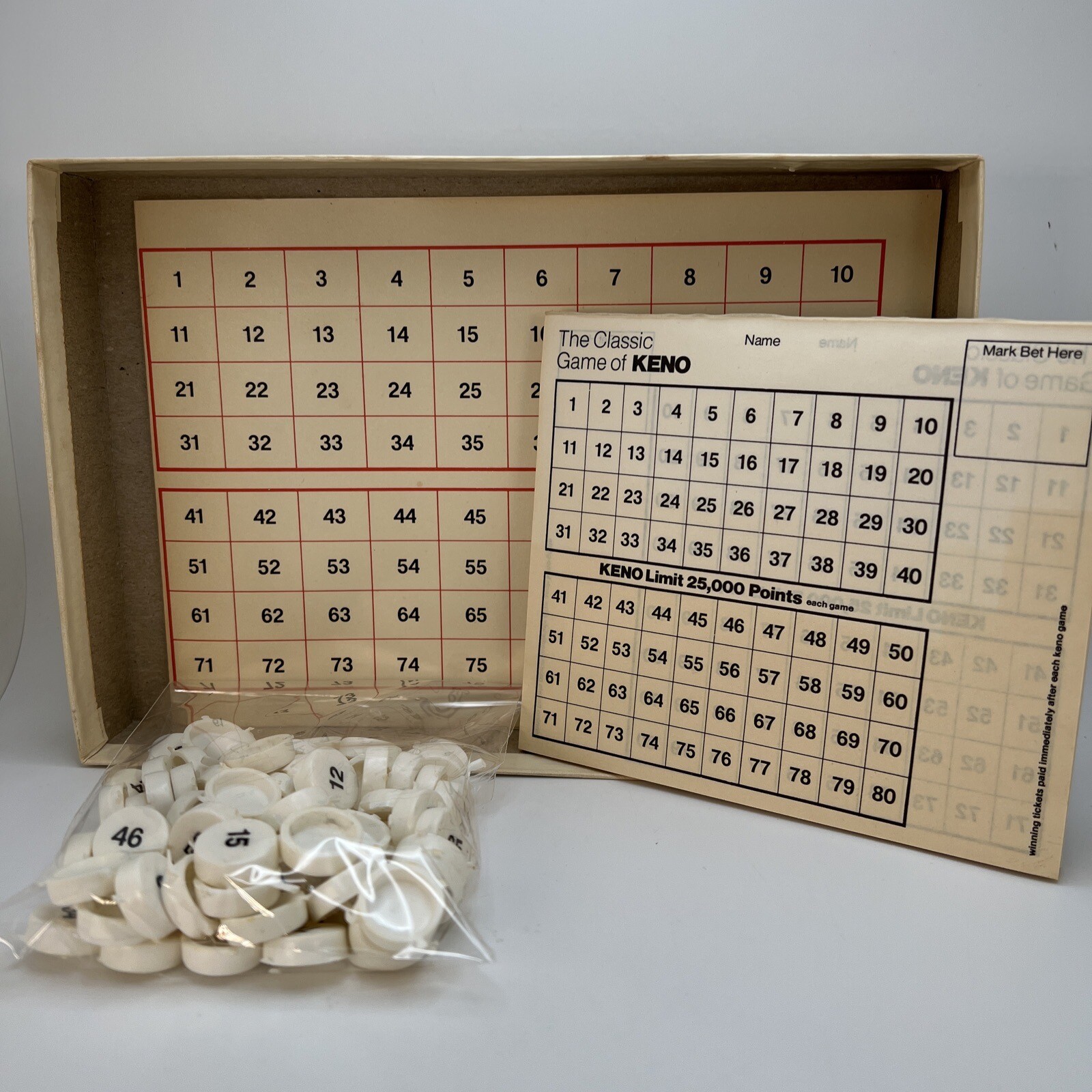 Vintage 1976 Classic Games Co. box with white script for “The Classic Game of KENO” and numbered red, yellow, and blue tokens.