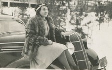 WOMAN IN FUR COAT SITTING ON FENDER OF EARLY MODEL CAR. 1930s B W PHOTO.
