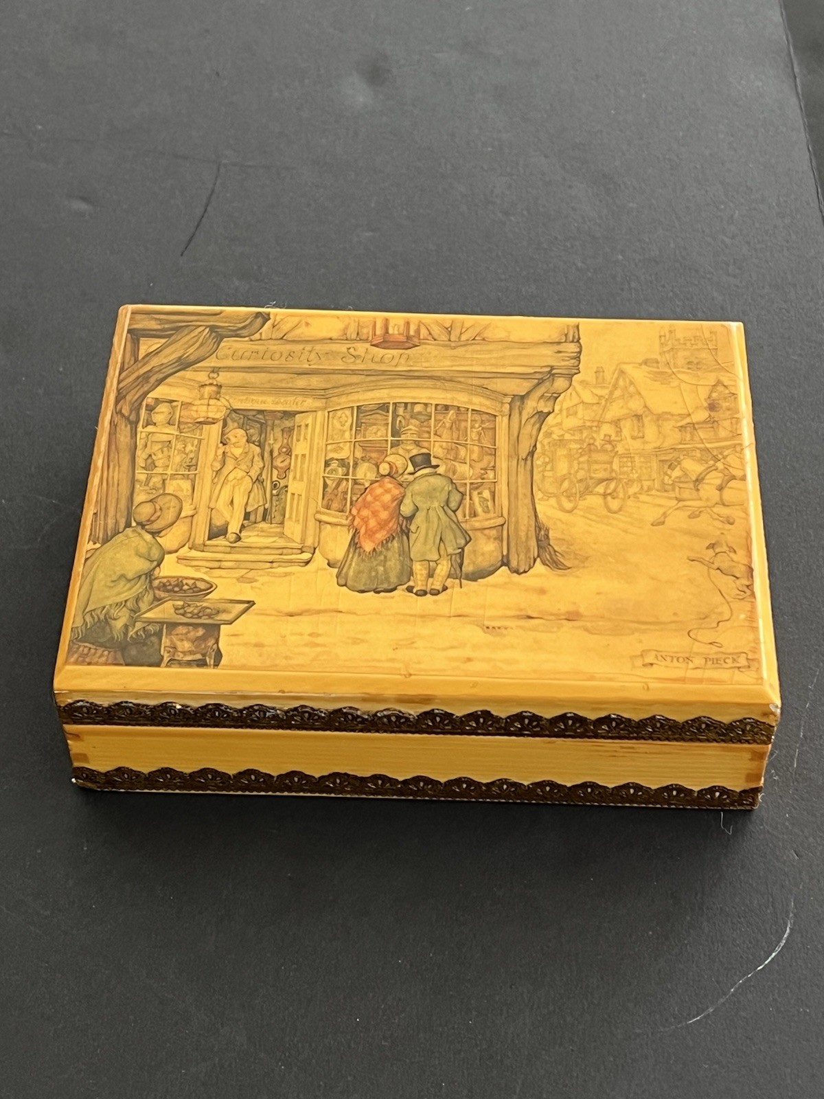 Vintage wooden double-deck playing card box with brass trim and illustrated curiosity shop scene.