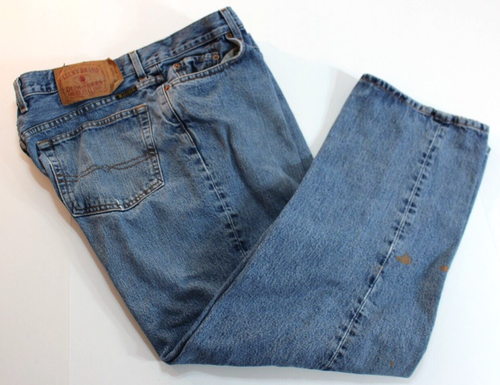 Blue VTG Lucky Brand jeans, 34x30, with brown paint splatter on left leg and tan leather patch on back pocket.