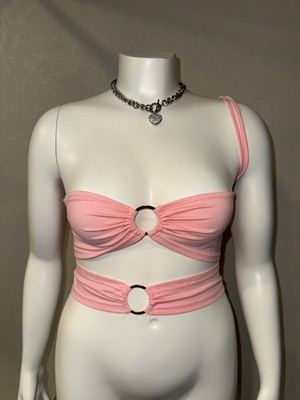 Stylish pink crop top with ring details. Features a unique one-shoulder design. 