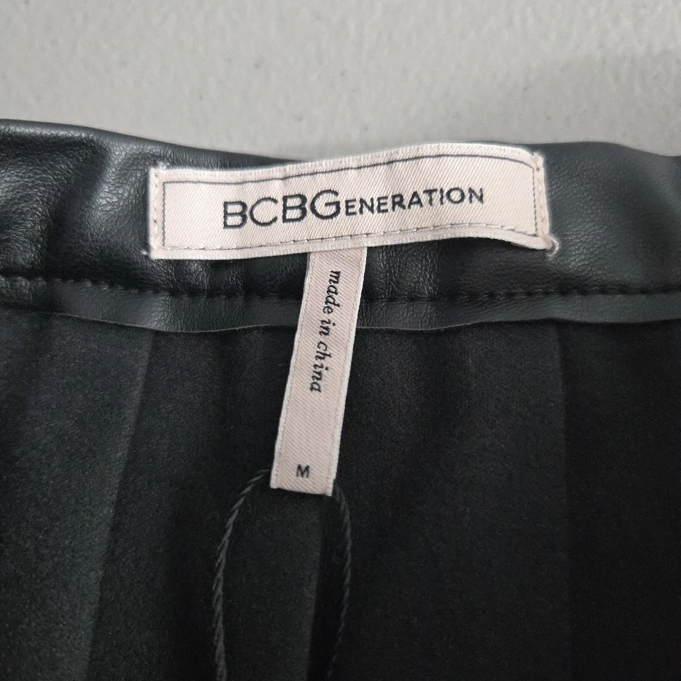 Falda plisada de cuero sintético negra mediana BCBGeneration para mujer Foto 3 de 4