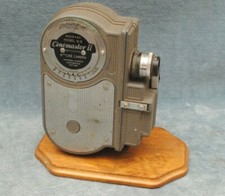 1940s UNIVERSAL CINEMASTER II MODEL G-8 8MM MOVIE CAMERA ON WOODEN DISPLAY STAND