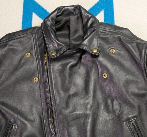 Black vintage leather Langlitz motorcycle jacket with snap buttons, front zipper, and two slit pockets, size 46.