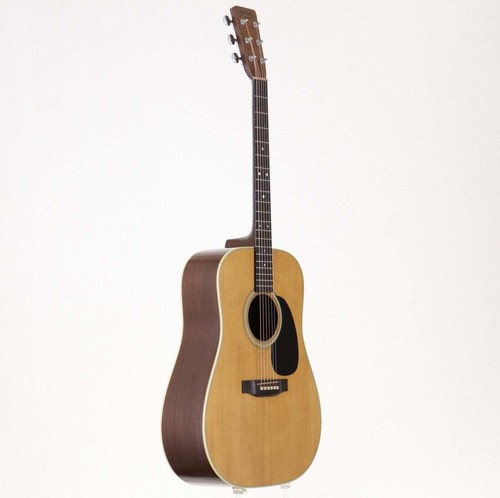 Martin D-28 acoustic guitar with light wood body, dark ebony neck twist, and silver hardware in black case.