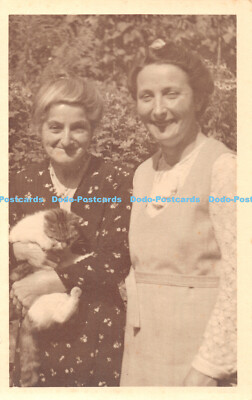 R408085 Zwei Frauen stehen im Garten Eine Frau mit einer Katze in der Hand