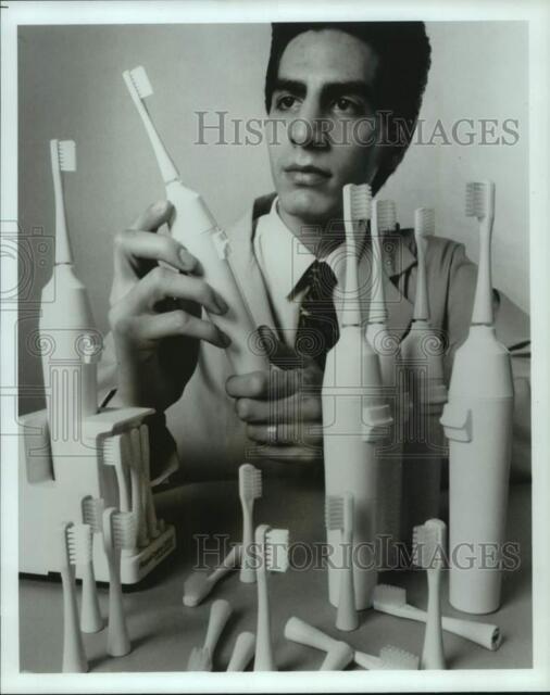 1992 Press Photo Jason Cloud inspects automatic toothbrush models Colorado