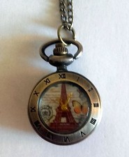 Superbe montre pendentif ronde décor tour Eiffel chiffres romains métal jaune