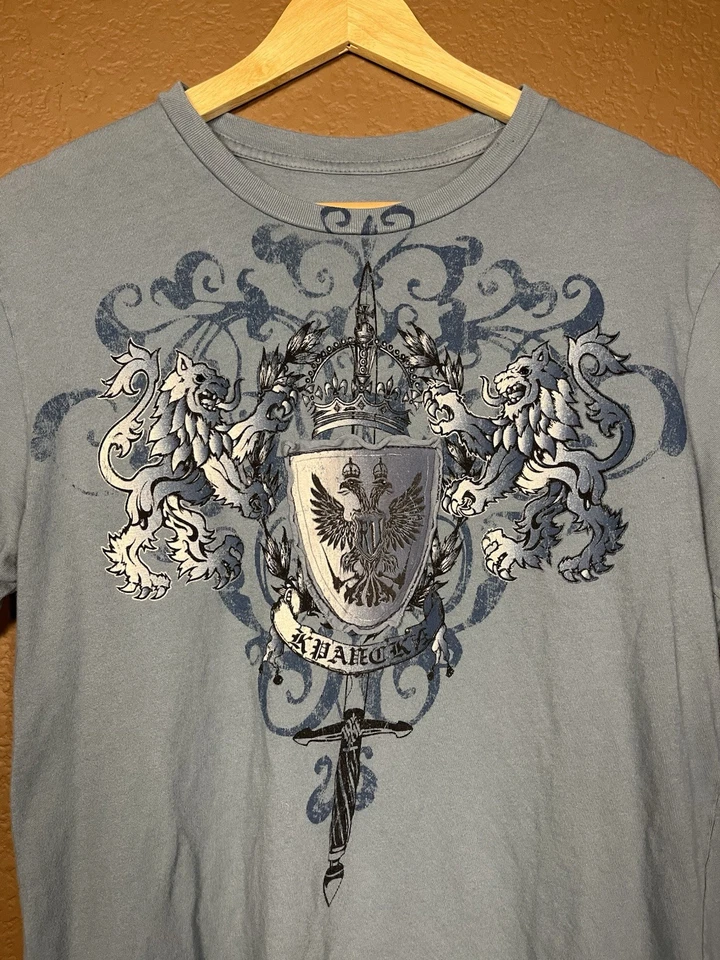 Camiseta Y2K Royal Underground Gráfica Cresta Leones Águila Escudo Espada Azul Gris Foto 2 de 4