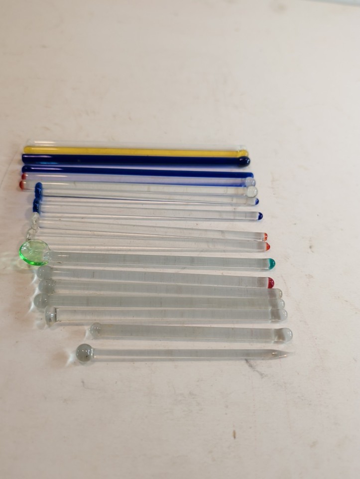17 mismatched vintage glass swizzle sticks in two sizes — the kind of charismatic barware detail that elevates a home cocktail setup instantly.