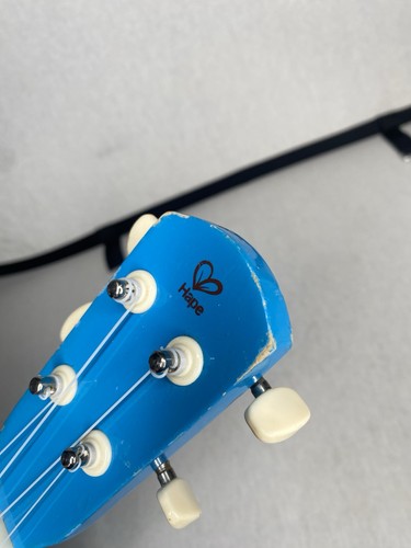 Ukelele de juguete de madera Hape de 21" para niños en azul/verde para preescolar y niño pequeño - Imagen 7 de 9