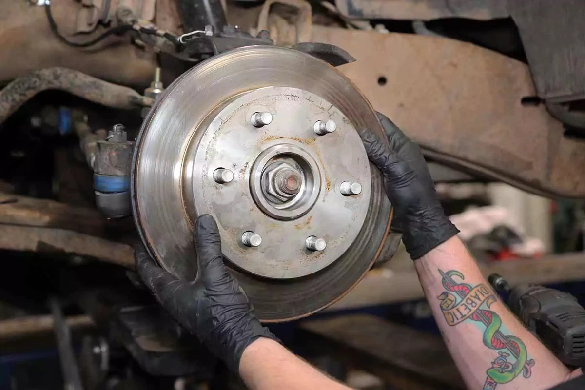 A mechanic reinstalls the brake rotor.