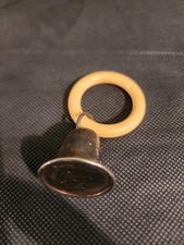 Vintage sterling silver baby rattle featuring a bell attached to a teething ring