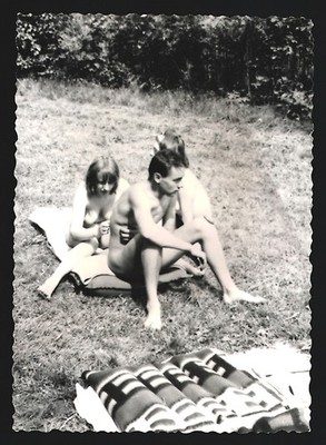 Fotografie Mann und zwei nackte Frauen sitzen auf einer Decke 