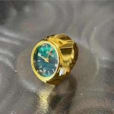 Gold watch ring with green face watch