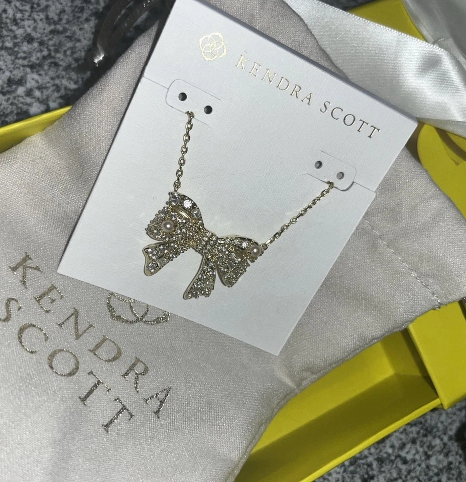 Collar colgante corto con lazo dorado Kendra Scott Krista en blanco mezcla en caja de regalo Foto 2 de 4