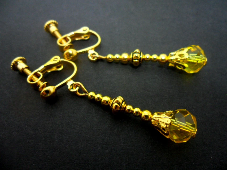 A PAIR OF GOLD TONE YELLOW AMBER GLASS CRYSTAL CLIP ON EARRINGS. NEW. - Image 1 of 1