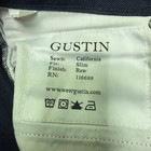 White fabric tag on Gustin jeans men 30x29 indigo raw selvedge denim slim fit made in USA with black printed text and icons.