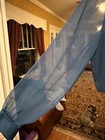 Blue sheer J.R. Nites fabric, size 12, with small embroidered logo, displayed on yellow couch indoors.
