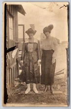 Postcard RPPC  Two Women Standing Board Hats feathers My sister & a Girl Cans