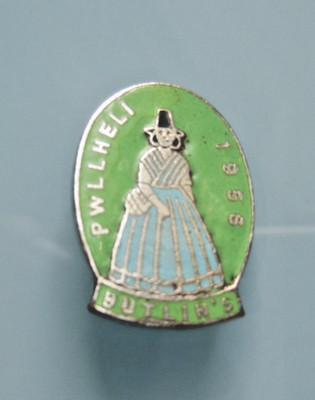 BUTLINS ABZEICHEN PWLLHELI 1956. WELSH LADY. GRÜNER HINTERGRUND. MAKER JEWELRY CO.