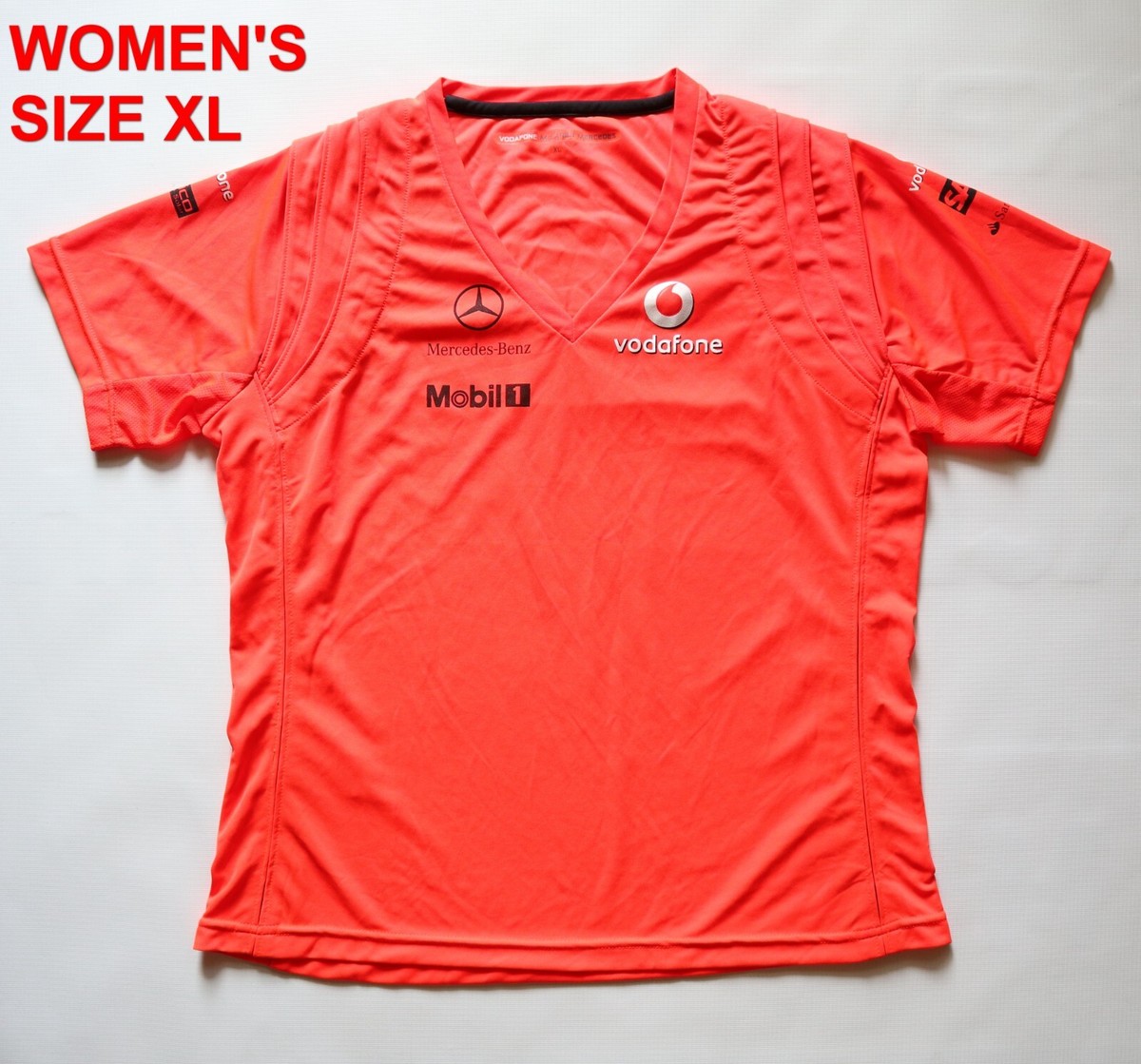 Lot - A Vodafone McLaren Mercedes official F1 team bright orange Hugo Boss XL polo / T-Shirt, signed below neck line in black marker by Jenson Button, exclusively given to team members