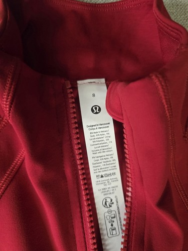 Red Lululemon Define Cropped Jacket with white zipper label showing size 8, care instructions, and black logo.