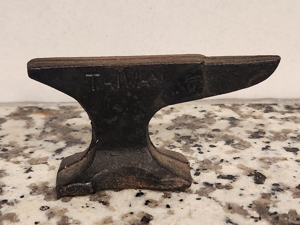 A cast iron miniature anvil paperweight from Taiwan — a satisfying, weighty desk object that's part tool mythology, part industrial sculpture.