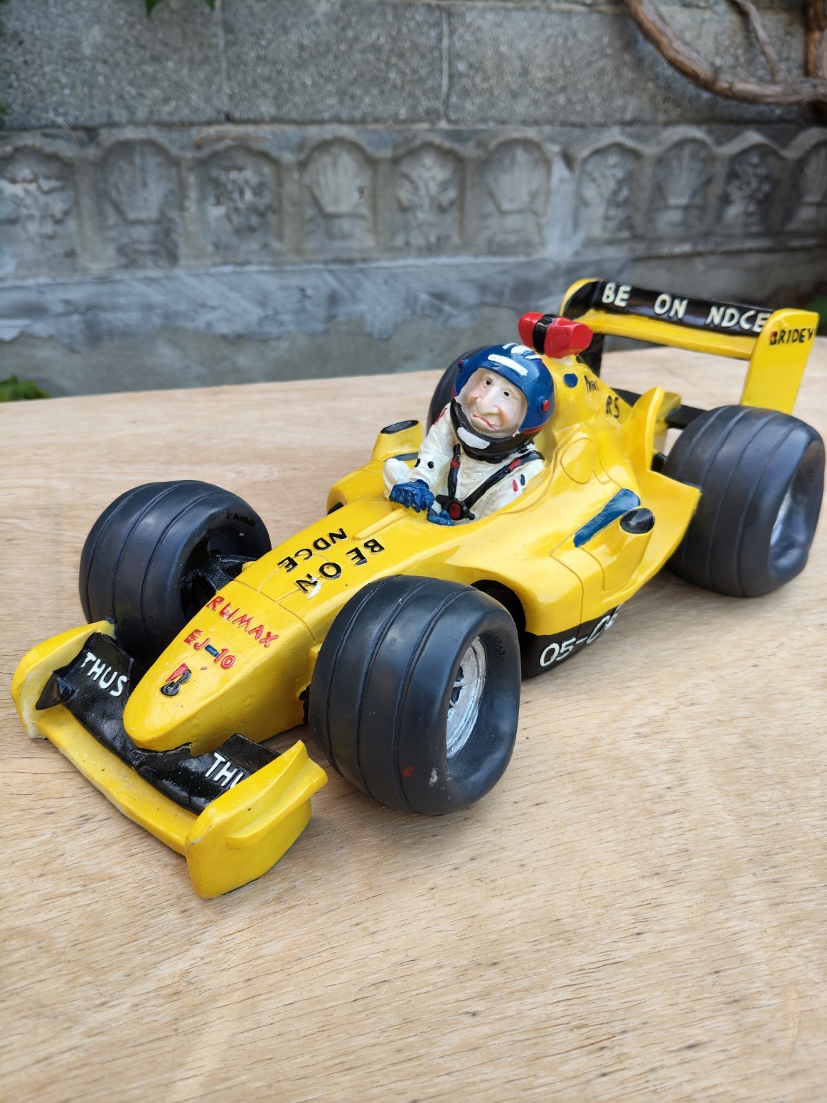 Modellino auto Formula 1 gialla in resina con pilota, scritte BE ON NDCE