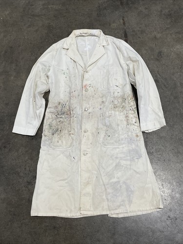 White vintage painters smock work wear with stained chest and shoulders, button front, and two large front pockets.