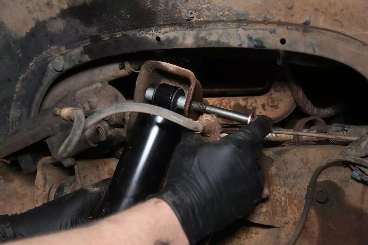 The upper bolt is slid through the eyelet and mount.